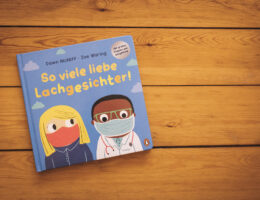 Das Buch-Cover von "So viele lieb Lachgesichter" zeigt zwei gezichente Menschen mit Maske, eine weiße Frau und einen Schwarzen Mann